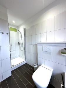 罗斯托克布林克曼多夫酒店的白色的浴室设有卫生间和淋浴。
