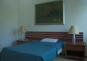 San MarcosHotel Boutique Sol de Oro的一间卧室配有一张蓝色的床、两个床头柜和两盏灯。