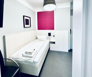 罗斯托克布林克曼多夫酒店的一间设有白色床和粉红色墙壁的客房