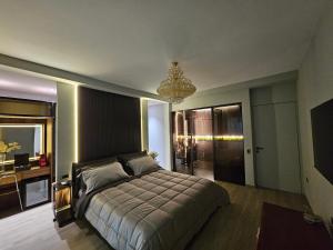 地拉那Blloku Suites, City Centre,Tirana的一间卧室配有一张大床和一个吊灯。