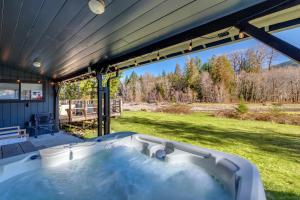 帕克伍德Waterfront Cabin at White Pass and Mount Rainier National Park的享有庭院景致的门廊上的热水浴池