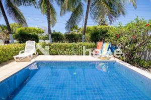 帕里普埃拉Casa a 5 minutos das Piscinas Naturais em Alagoas的一个带两把草坪椅的游泳池和一个游泳池