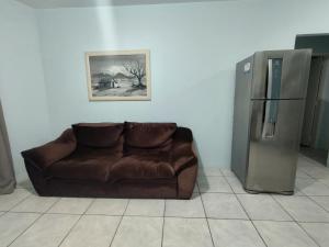 因贝Pousada Golfinhos的一间配备有冰箱的客房内的棕色沙发