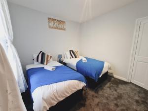 BelvedereBelvedere House 2 bedroom Greater London的蓝色和白色的客房内的两张床
