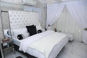 韦尔科姆Villa Grande Luxury accommodation的卧室配有白色大床和白色窗帘
