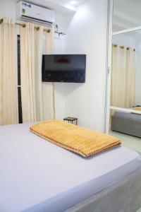 达喀尔Happyhomes的卧室配有一张壁挂式平面电视的床。