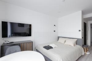 维尔纽斯Ozo eco apartments 5的一间卧室配有一张床和一台平面电视
