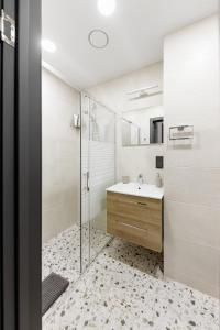 维尔纽斯Ozo eco apartments 5的一间带玻璃淋浴和水槽的浴室