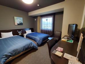 龟山鲁特因戴尼卡亚玛英特酒店的酒店客房设有两张床和电视。