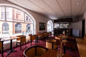 欧登塞Milling Hotel Windsor的餐厅设有桌椅和大窗户。