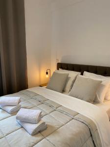 阿特米达Apartment near Athens Airport, Rafina Port and Sea的一张白色的大床,带两条毛巾