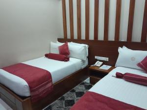 姆贝亚HOTEL MDOPE MBEYA的酒店客房 - 带两张带红色枕头的床