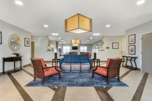 杰克逊维尔Comfort Suites West Jacksonville的客厅配有沙发和两把椅子