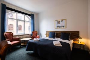 欧登塞Milling Hotel Windsor的一间卧室配有床、椅子和窗户