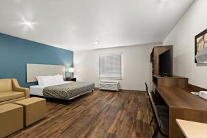 埃文代尔WoodSpring Suites Tolleson - Phoenix West的一间酒店客房,配有一张床和一台电视