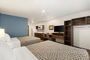 埃文代尔WoodSpring Suites Tolleson - Phoenix West的酒店客房配有两张床和一张书桌
