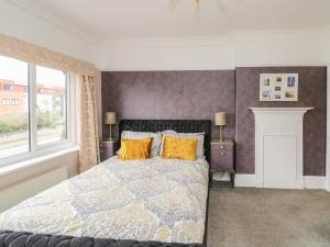 科尔温湾Glendalough的一间卧室配有一张带黄色枕头的床