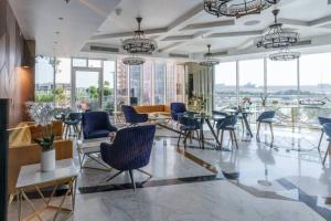 迪拜Dubai Sleek & Cozy Space的大型客房设有桌椅和窗户。
