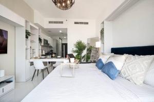 迪拜Dubai Sleek & Cozy Space的一间带白色大床的卧室和一间厨房