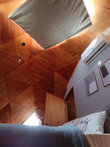 塔夸伦博Domo guidaí的客房设有一张床和木制天花板
