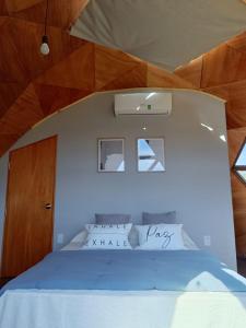 塔夸伦博Domo guidaí的一间卧室设有一张带木制天花板的大床