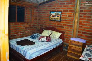 伊瓦拉Casa de campo independiente sector Chachimbiro –Urcuqui的卧室配有砖墙内的床铺