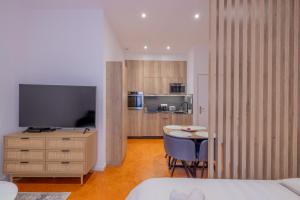 普罗旺斯艾克斯Appartement de Charme的客房设有带桌子和电视的卧室。