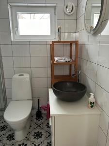 斯德哥尔摩Gästhus nära city och Älvsjömässan的一间带黑色水槽和卫生间的浴室