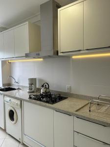 拉热斯Apartamento NOVO no centro/Via Gastronômica的厨房配有炉灶和洗衣机。