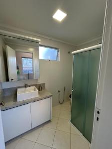 拉热斯Apartamento NOVO no centro/Via Gastronômica的一间带水槽和玻璃淋浴的浴室