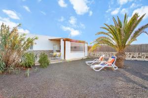 拉哈雷斯Casa Filale Sun and Relax的一座房子,配有两把草坪椅和棕榈树