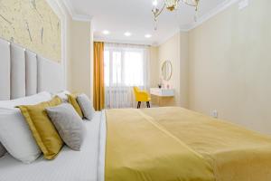 阿斯塔纳Amor de Astaná, ЖК Симфония, 3 комнатная的一间卧室配有一张带黄色毯子的大床