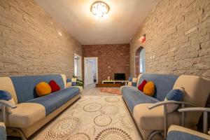 于尔居普Kapadokya Hatice Ana Tatil Evi的客厅设有蓝色的沙发和砖墙