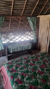 PuahuaMahana Tua Lodge Huahine的一间卧室设有一张床和一个窗口