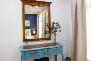 梅德斯通Elegant 4 bedroom, Maidstone house by Light Living Serviced Accommodation的蓝色梳妆台,带镜子和花瓶
