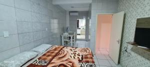 沙佩科Loft Confortável no Centro的客房设有一张床和一间带电视的浴室。