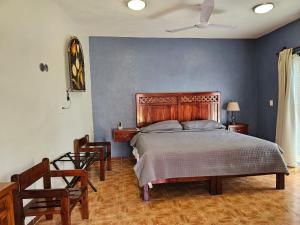 巴利亚多利德Casa Xu´unan的一间卧室配有一张大床和两把椅子