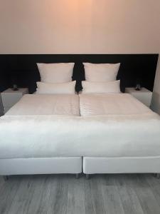 巴特赫尔斯费尔德Haus am Waldrand的一张白色的大床,配有白色枕头
