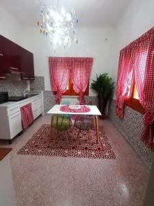 帕拉比塔VILLA DAILA的一间厨房,内设桌子和红色窗帘