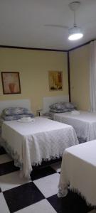 巴西利亚KzaZenDF CamaeCafé AsaSul的一间卧室配有两张带白色床单的床