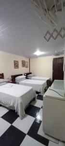 巴西利亚KzaZenDF CamaeCafé AsaSul的黑白格底楼的客房,配有三张床