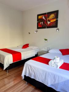 塔拉波托Residencial Marina House的一间卧室配有两张红色和白色床单