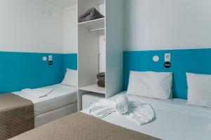 马塞约Zuza Slim Suítes的蓝色和白色的客房内的两张床