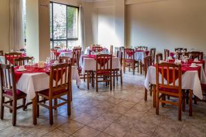 科恰班巴Hotel Oblitas的餐厅配有桌椅和红白桌布