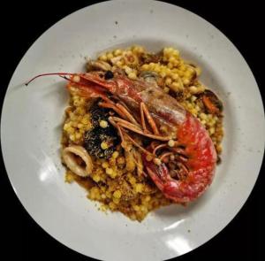 BorraS'INCONTRU A CA' DELL' ALPINO的盘子上带虾的白盘食物