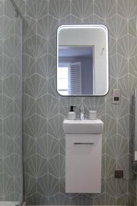 切尔滕纳姆New, Luxury Apartment in Town Centre的浴室设有水槽和墙上的镜子