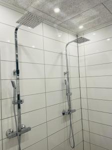 比伦德Private Rooms in center of Billund的浴室铺有白色瓷砖,设有淋浴。