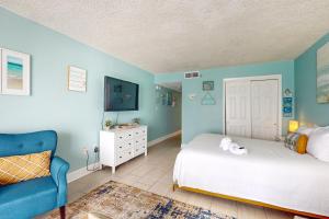 沃尔顿堡滩Islander W 703的一间卧室设有一张床和蓝色的墙壁
