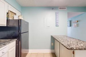 沃尔顿堡滩Islander W 703的厨房配有冰箱和台面