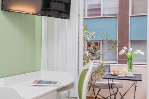 卡利亚里Residenze Asproni Serviced Apartments的客房设有白色的办公桌和窗户。